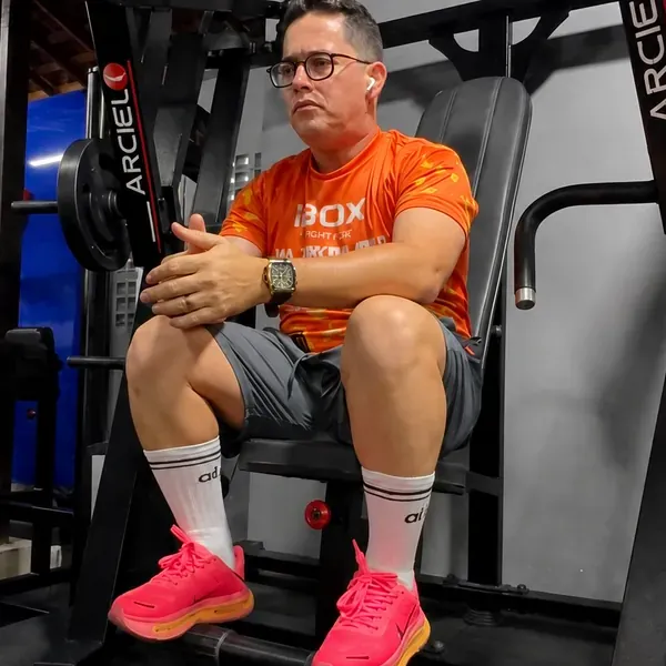 Chaveirinho com camisa da iBox Protege sentado em um aparelho de academia como embaixador da marca